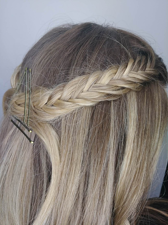 Side view of a person's head showing a styled braid with hairpins in straight blond hair. - K. Charles & Co. in Schertz, TX