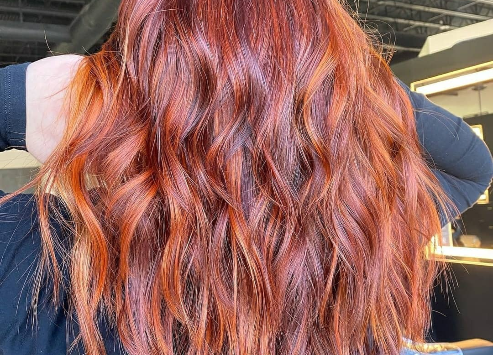Vibrant copper-red hairstyle with loose curls viewed from behind. - K. Charles & Co. in Schertz, TX