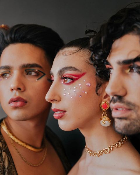 Three individuals with artistic makeup from a salon, featuring bold red and black designs, and adorned with fashionable jewelry. - K. Charles & Co. in Schertz, TX