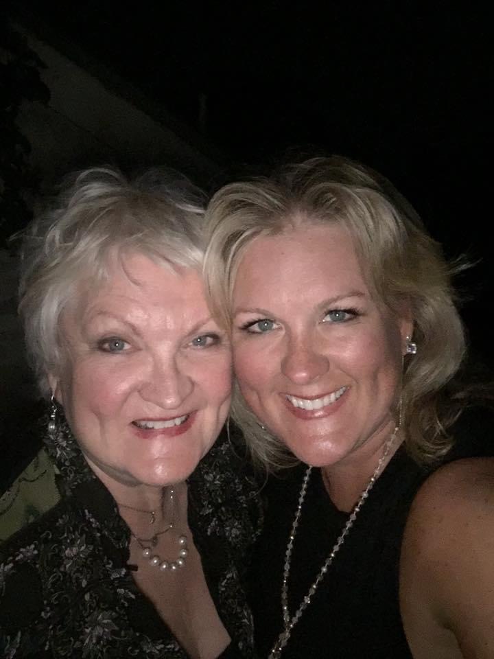 Two women smiling for a selfie at night, one with short blonde hair and the other with medium-length blonde hair, both wearing dark outfits and pearl earrings. - K. Charles & Co. in Schertz, TX